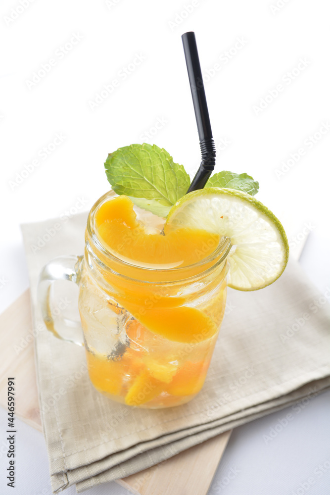 cold iced mango peach fruit juice with lemon mint leaf in glass jar white background asian beverage halal menu cold iced mango peach fruit juice with lemon mint leaf in glass jar white background asian beverage halal menu