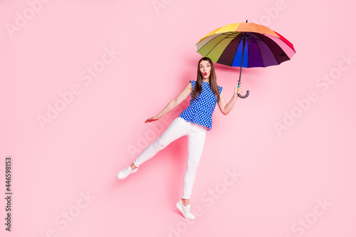 Full length body size view of attractive cheery funny brown-haired girl holding parasol having fun isolated over pink pastel color background
