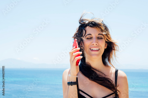 Portrait of woman talking on cellphone near the sea