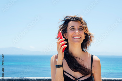 Woman talking with mobile phone near the beach