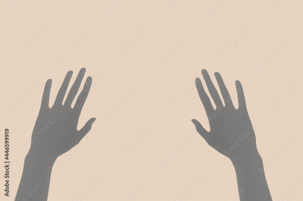 Abstract image of the pair of hand shadows on the pastel  beige background.