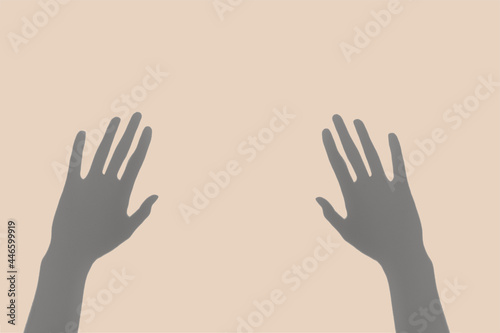 Abstract image of the pair of hand shadows on the pastel  beige background.