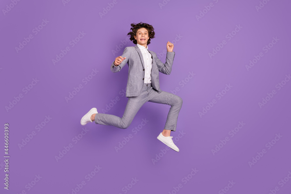 Photo of active energetic kid guy jump run enjoy weekend wear grey suit sneakers isolated violet color background