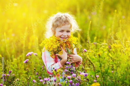 Happy girl in a field with a bouquet of flowers