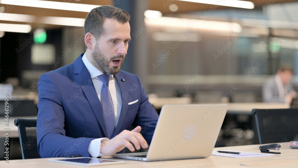 Middle Aged Businessman Feeling Shocked while using Laptop Middle Aged Businessman Feeling Shocked while using Laptop