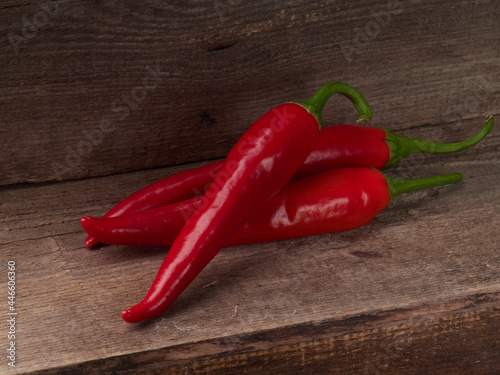 Red hot chili peppers on old wooden table