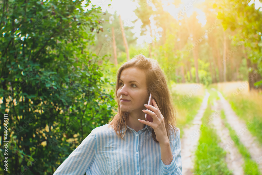 Beautiful girl with fair hair is talking on phone in forest. Young woman lost on the nature. No signal phone connection. Beautiful girl with fair hair is talking on phone in forest. Young woman lost on the nature. No signal phone connection.