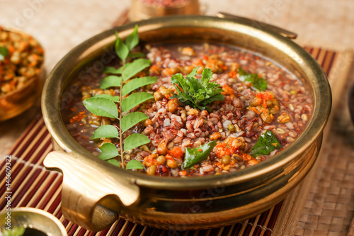 Ayurvedic porridge, Karkidaka Kanji herbal gruel in brass golden bowl Kerala South India. Ayurveda diet health drink for immunity, cleanse the body. Top view medicinal rice porridge Indian veg food