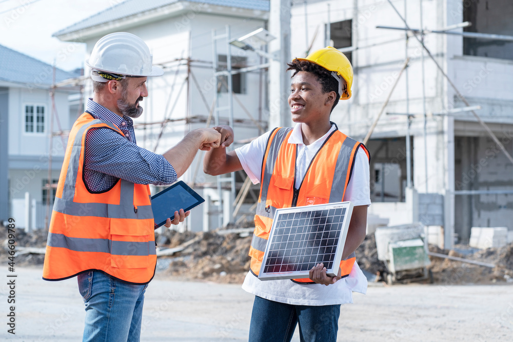 Male engineer taining African American workers how to install solar panels and greet each other in construction sites in housing projects. Male engineer taining African American workers how to install solar panels and greet each other in construction sites in housing projects.