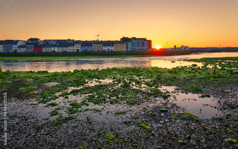 Beautiful morning orange sunrise cityscape with colorful houses by the Corrib River at Claddagh, Galway City, Ireland 