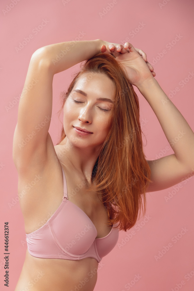 Young beautiful woman in lingerie posing isolated over pink studio background. Natural beauty, purity, diet, sports, healthy lifestyle and aesthetic cosmetology concept. Young beautiful woman in lingerie posing isolated over pink studio background. Natural beauty, purity, diet, sports, healthy lifestyle and aesthetic cosmetology concept.