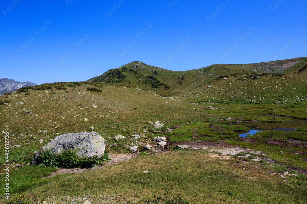 mountain landscape with big stone and small lake in alpine meadows of caucasus mountain landscape with big stone and small lake in alpine meadows of caucasus
