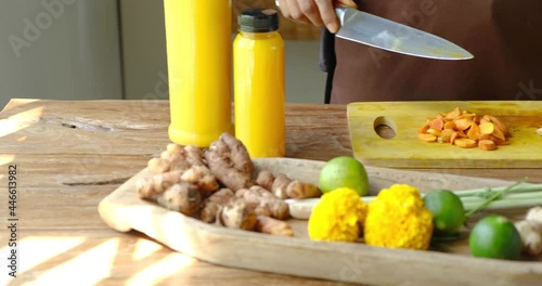 Close up of two women cutting herbs, roots and spices for traditional homemade Jamu drink- Indonesian herbal beverage with natural ingredients: turmeric, ginger, lime, lemongrass, tamarind, lemon