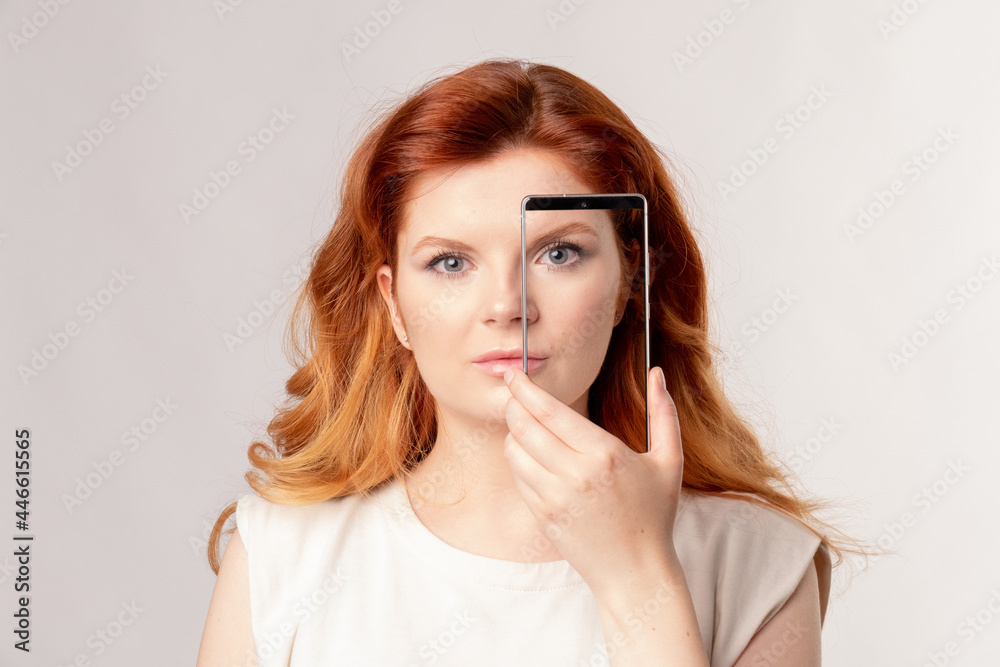 Red-hair women covers her face screen smartphone Red-hair women covers her face screen smartphone