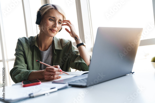 Middle aged blonde woman with short hair studying