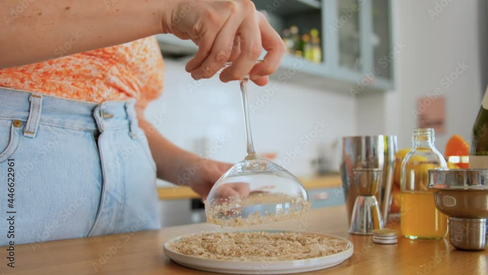 drinks and people concept - young woman making cocktail and spreading lime juice around rim of glass at home kitchen drinks and people concept - young woman making cocktail and spreading lime juice around rim of glass at home kitchen