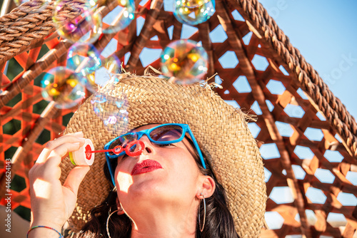 beautiful girl with sunglasses making soap bubbles outdoor