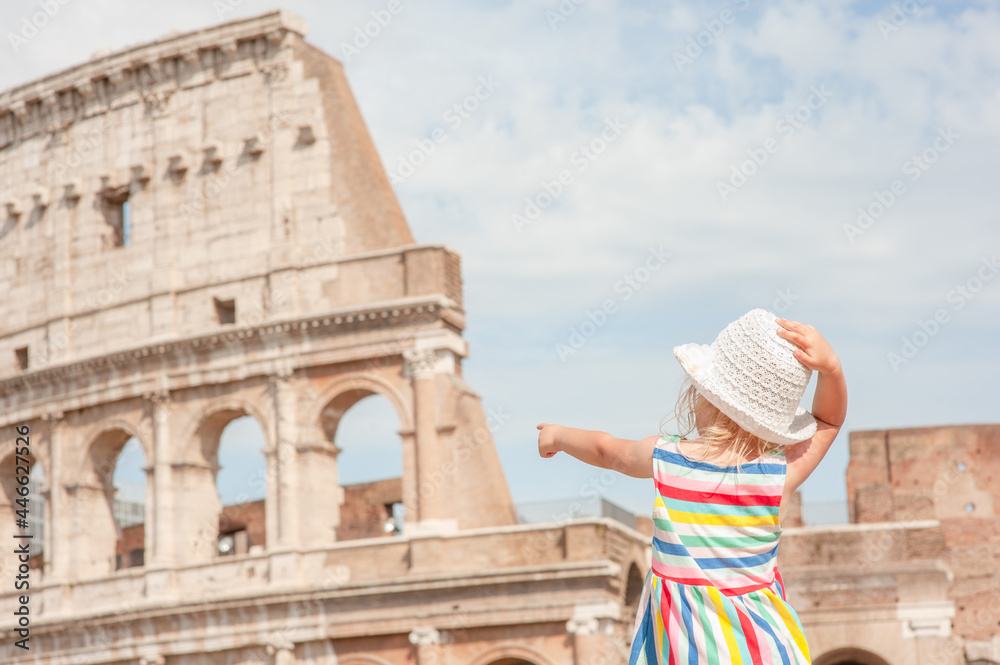little girl points the finger at the coliseum  in Rome, Italy. Back view