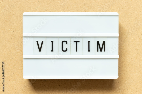 Lightbox with word victim on wood background photo