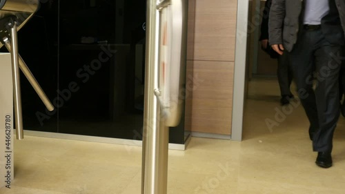 Business people leave the office rooms. Legs of crowd people leaving the office rooms and pass turnstile