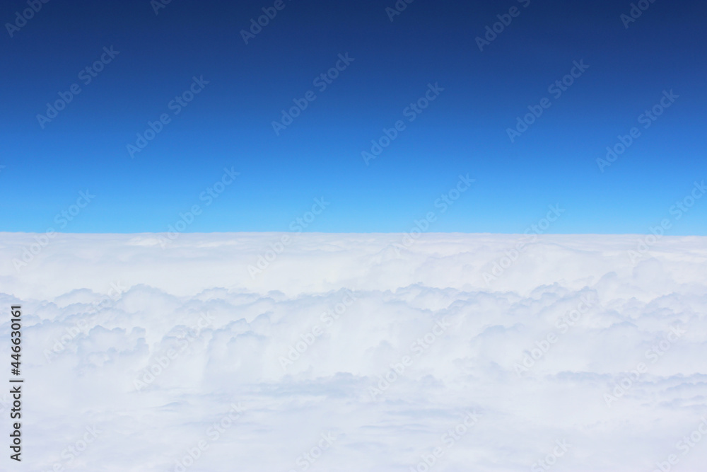Cloud and sky pastel colors abstract nature background. airplane and green landscape, river, mountain, clouds background. View from the airplane window. Airplane wing flying above the clouds. Top view