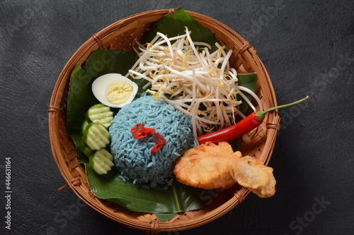 Nasi kerabu or nasi ulam, popular Malay rice dish. Blue color of rice resulting from the petals of butterfly-pea flowers. Traditional Malaysian food, Asian cuisine. photo