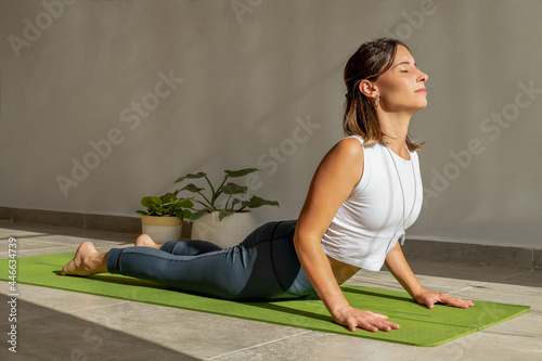 young woman practicing yoga cobra pose