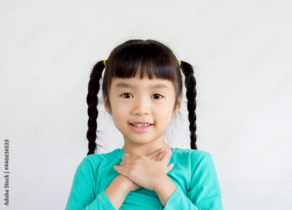 asian child with pigtails hair style and join her hands on her breast asian child with pigtails hair style and join her hands on her breast