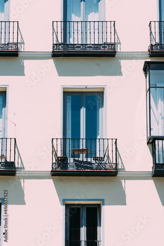 Slika na platnu Vertical shot of beautiful symmetrical balconies on a clean building with the su