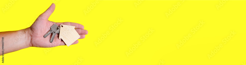 Banner, house keys with keychain in hand on yellow background. Banner, house keys with keychain in hand on yellow background.