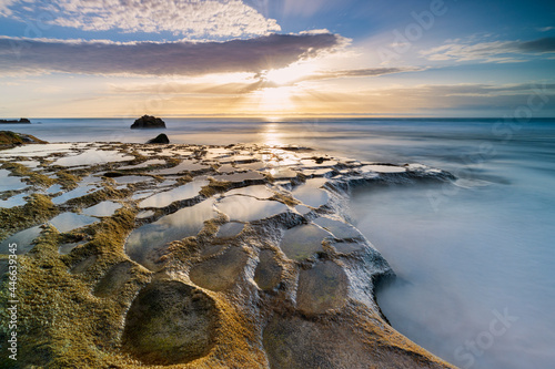 Golden hour over the ocean waves and rocks at El Cotillo beach, Fuerteventura, Canary Islands, Spain photo