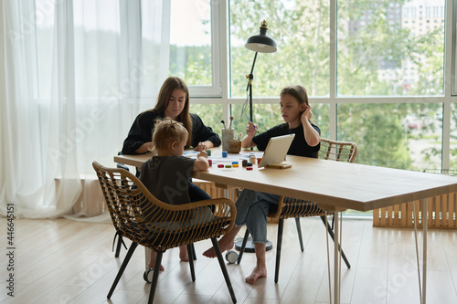 Wallpaper Mural  mom and her children girls are sitting at the table and drawing with paints using an online lesson on a tablet            Torontodigital.ca