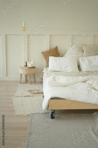  bedroom with a bed on wheels and white bed linen rugs and a bedside table     