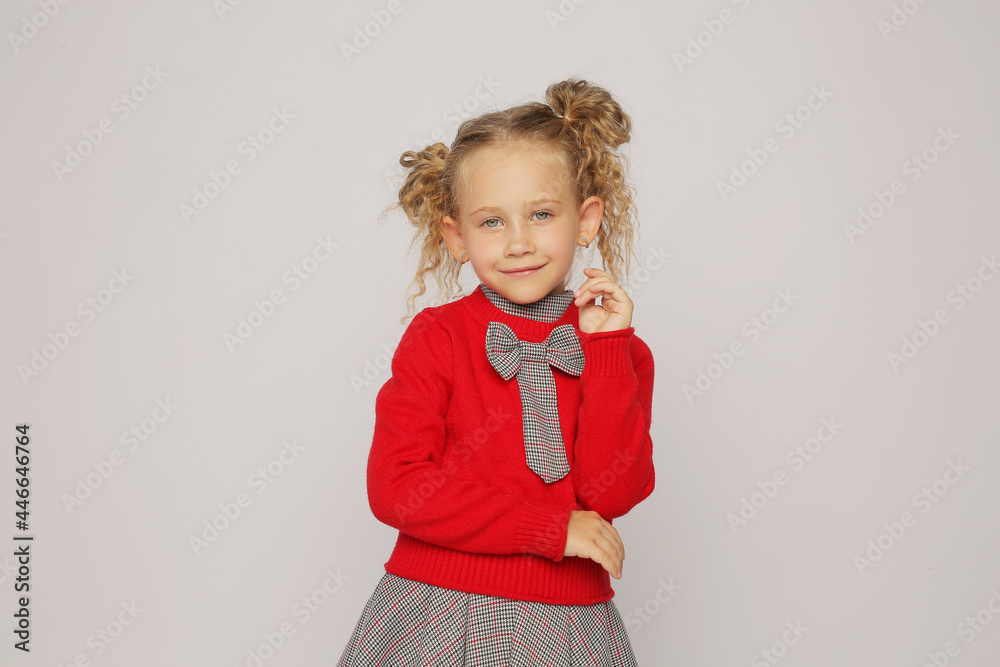 beautiful blonde girl in a red jumper sweater in a gray school dress with long hair portrait with different emotions beautiful blonde girl in a red jumper sweater in a gray school dress with long hair portrait with different emotions