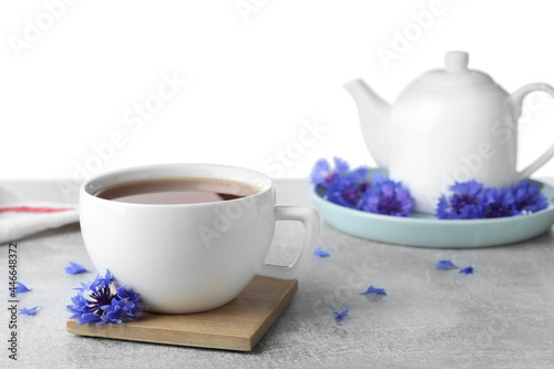 Cornflower tea and fresh flowers on grey table