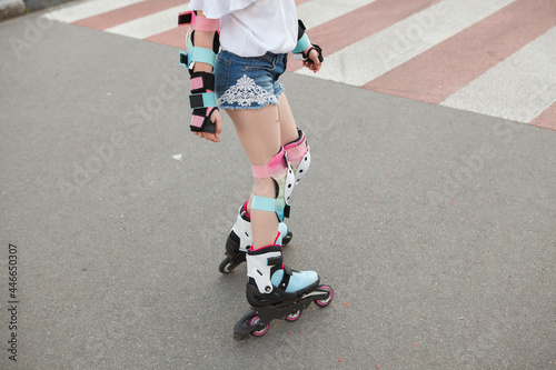 Cropped shot of unrecognizable girl wearing protective gear, rollerblading