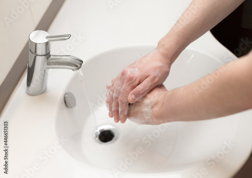 Hand washing. A man washes his hands with soap close up. Personal hygiene and health care concept.