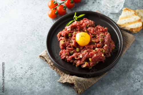 Foto Traditional beef steak tartare with egg yolk