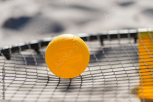 Spike ball game with yellow ball on sand. Summer game concept