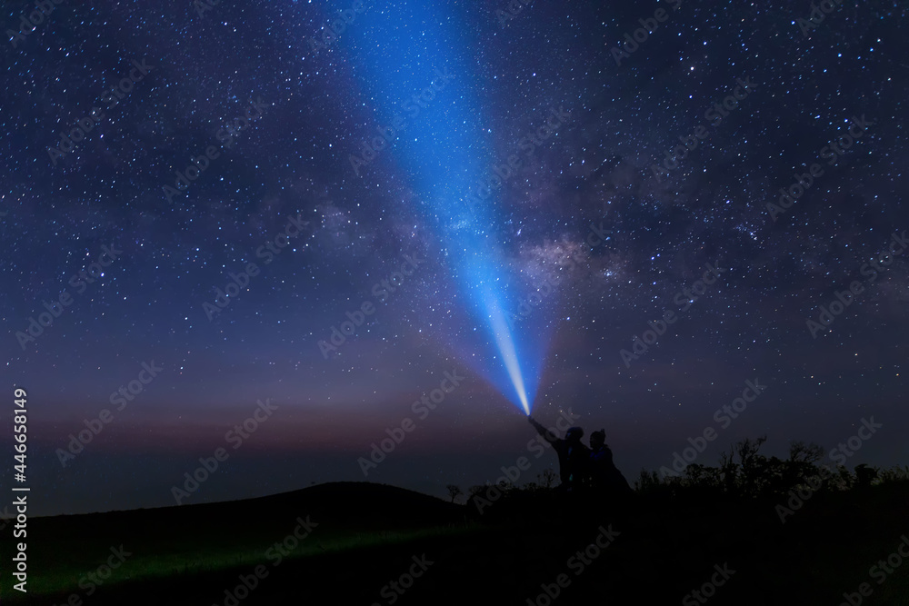 Colorful night sky with stars. Background with galaxy.  man with flashlight point to the starry sky at midnight.