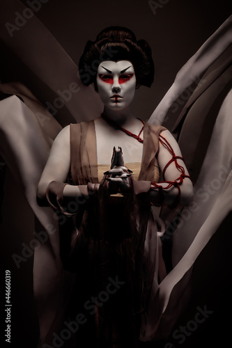Praying geisha, wearing a ceremonial dress creating voluptuousness in the wind
