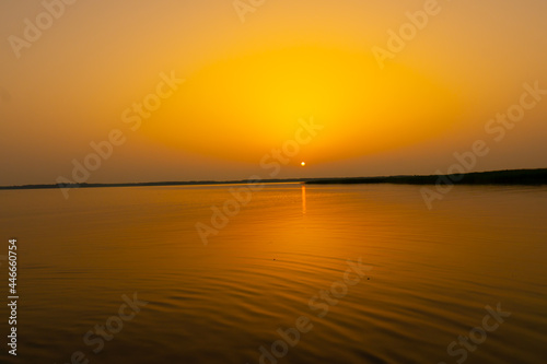 sunset at coast of the lake. Nature landscape. Nature in northern Europe. reflection, blue sky and yellow sunlight. landscape during sunset. © netsay