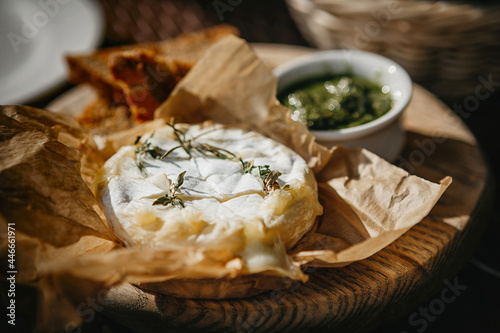 Konstfotografi Oven baked camembert cheese with rosemary and pesto sauce on baking paper