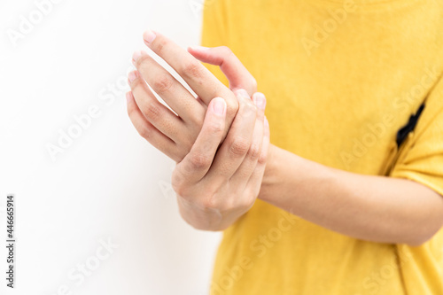 Woman using hand to hold other her palm with feeling pain, hurt and tingling. Concept of Guillain barre syndrome and numb hands disease.