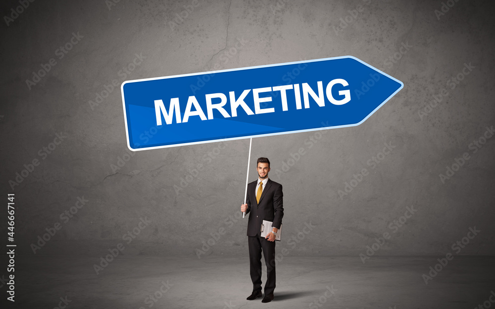 Young business person in casual holding road sign Young business person in casual holding road sign