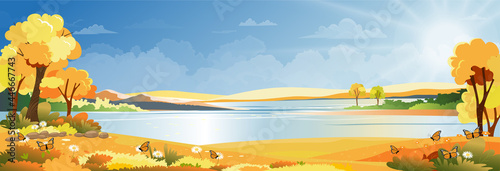 Autumn landscape at village by the river with grass land and mountain with blue sky and clouds, Vector Cartoon Autumnal Panoramic countryside by the lake with sunrise,Fall season background