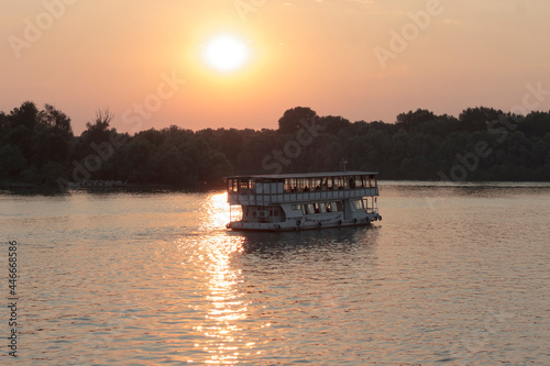 boat with tourists in the rays of sunlight at sunset.