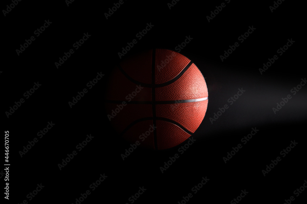 Basketball on black background in the dark with copy space