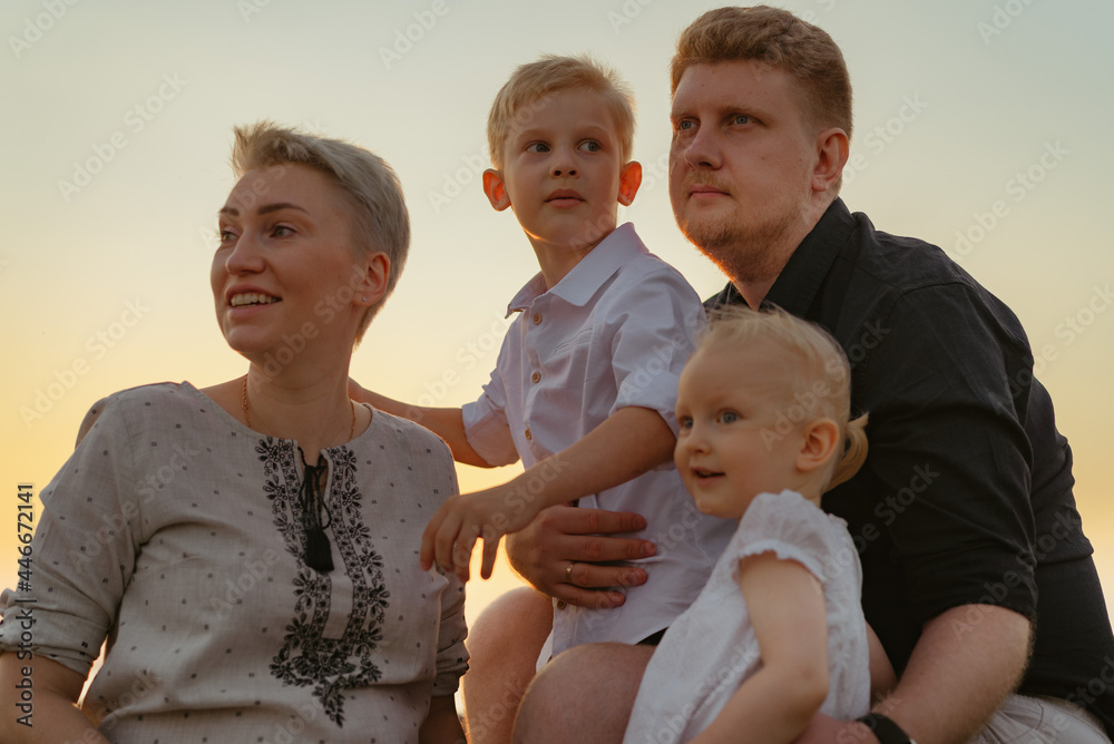 portrait of loving caucasian family enjoying sunset on summer evening.