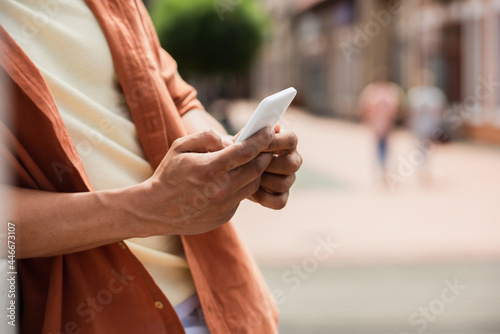cropped view of african american man using smartphone outdoors